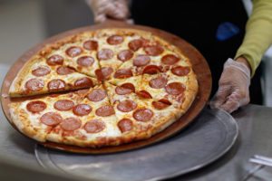 MIRAMAR, FL - NOVEMBER 18: Terry Cheung prepares a pizza pie to be served to students at Everglades High School on November 18, 2011 in Miramar, Florida. Monday evening the United States Congress passed a spending bill with a provision that would allow schools to count pizza as a vegetable.