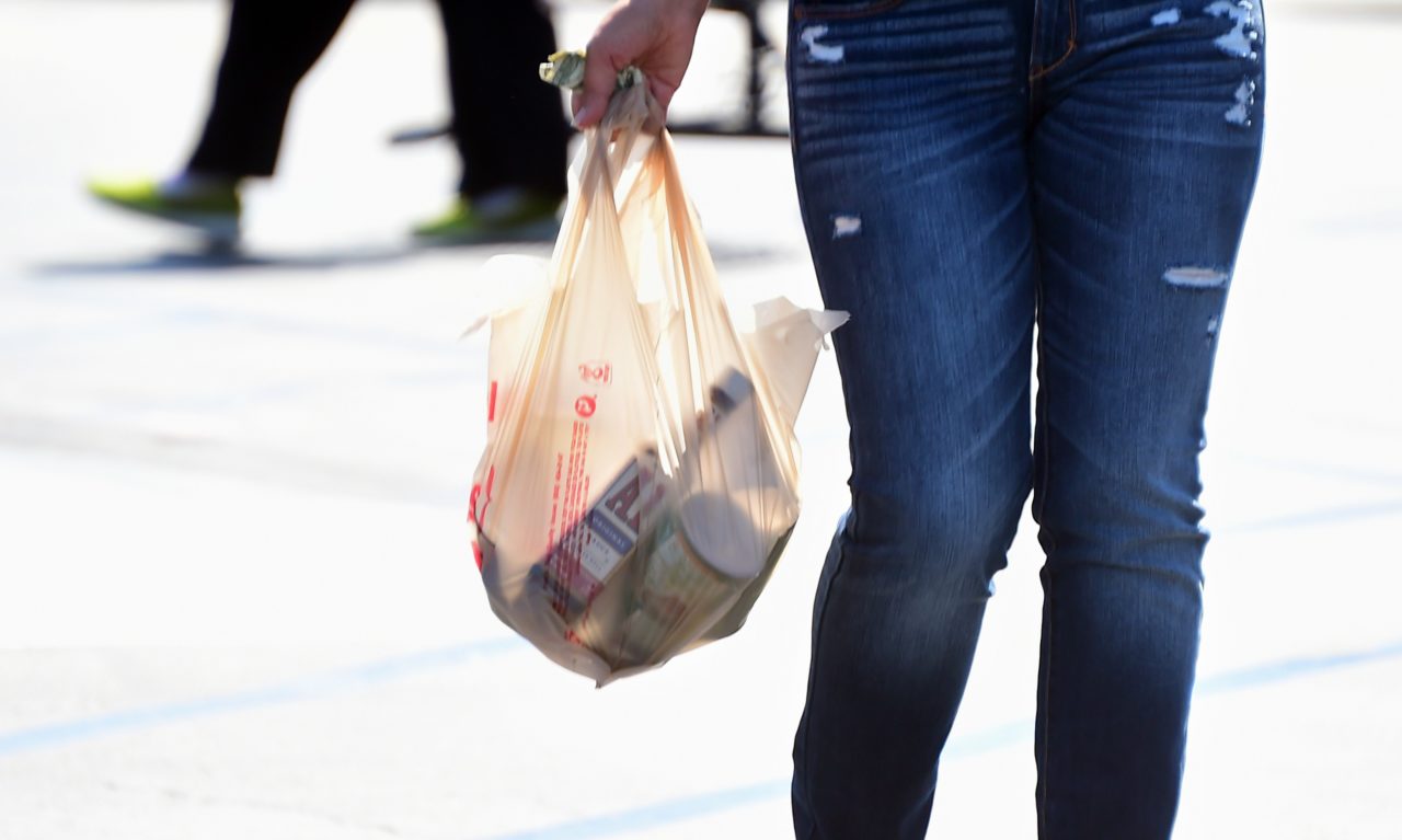 A woman carries her groceries in a plastic bag while leaving a supermarket in Monterey Park, California on September 30, 2014, where the state's Governor has signed the country's first statewide ban on single-use plastic bags from convenience and grocery stores. The ban, scheduled to take effect in July 2015, has led to a national coalition of plastic bag manufacturers immediately saying it will seek a voter referendum to repeal the law. AFP PHOTO / Frederic J. BROWN