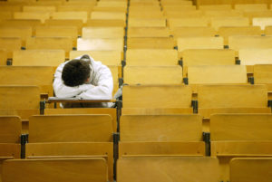 BERLIN, GERMANY - JANUARY 13: A student naps in a lecture hall at the Freie Universitaet January 13, 2003 in Berlin, Germany. The German university system is facing cuts of EUR 75 million in state funding over the next four years as the German government pushes through financial reforms. German politicians are also deliberating whether to start making students pay for at least a portion of the costs of their university education, though the proposal has met with fierce resitance from students, who went on strike across Germany last month. (Photo by Sean Gallup/Getty Images)
