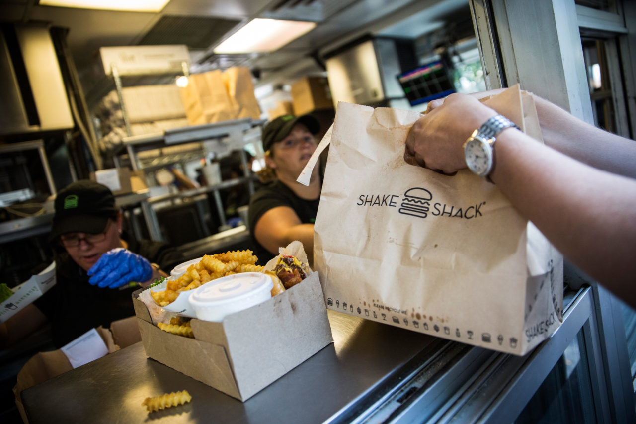 NEW YORK, NY - AUGUST 18: Customers pick up their orders from Shake Shack on August 18, 2014 in Madison Square Park in New York City. Shake Shack is allegedly considering going public and holding an initial price offering (IPO). (Photo by Andrew Burton/Getty Images)