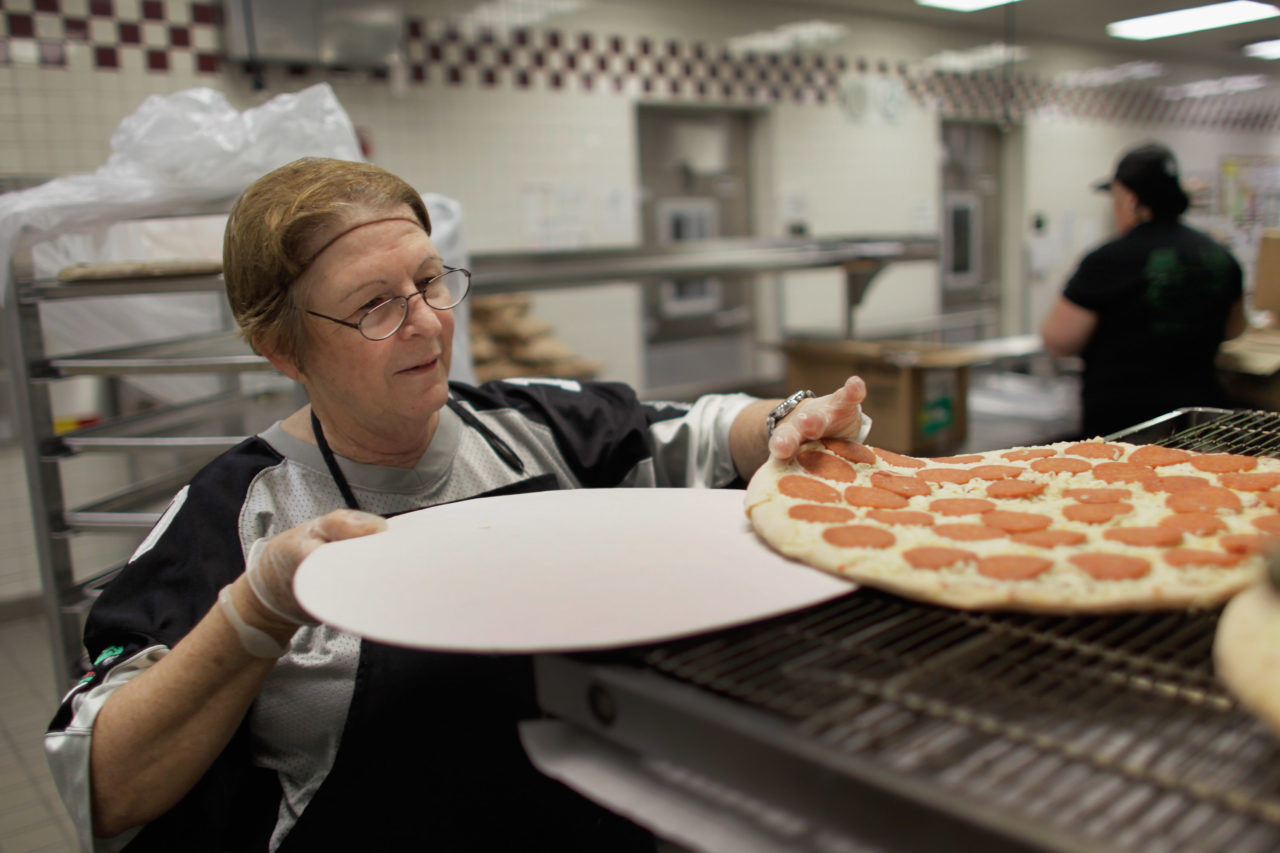 MIRAMAR, FL - NOVEMBER 18: Alina Bernardini places pizza pies into the oven during preparations for serving students lunch at Everglades High School on November 18, 2011 in Miramar, Florida. Monday evening the United States Congress passed a spending bill with a provision that would allow schools to count pizza as a vegetable. (Photo by Joe Raedle/Getty Images)