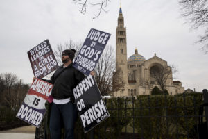 WASHINGTON, DC - FEBRUARY 20: Samuel Phelps-Roper, a member of the Westboro Baptist Church, protests outside of the Basilica of the National Shrine of the Immaculate Conception, February 20, 2016 in Washington, DC. Scalia, who died February 13 while on a hunting trip in Texas, layed in repose in the Great Hall of the Supreme Court on Friday and his funeral service will be at the basillica today. (Photo by Drew Angerer/Getty Images)