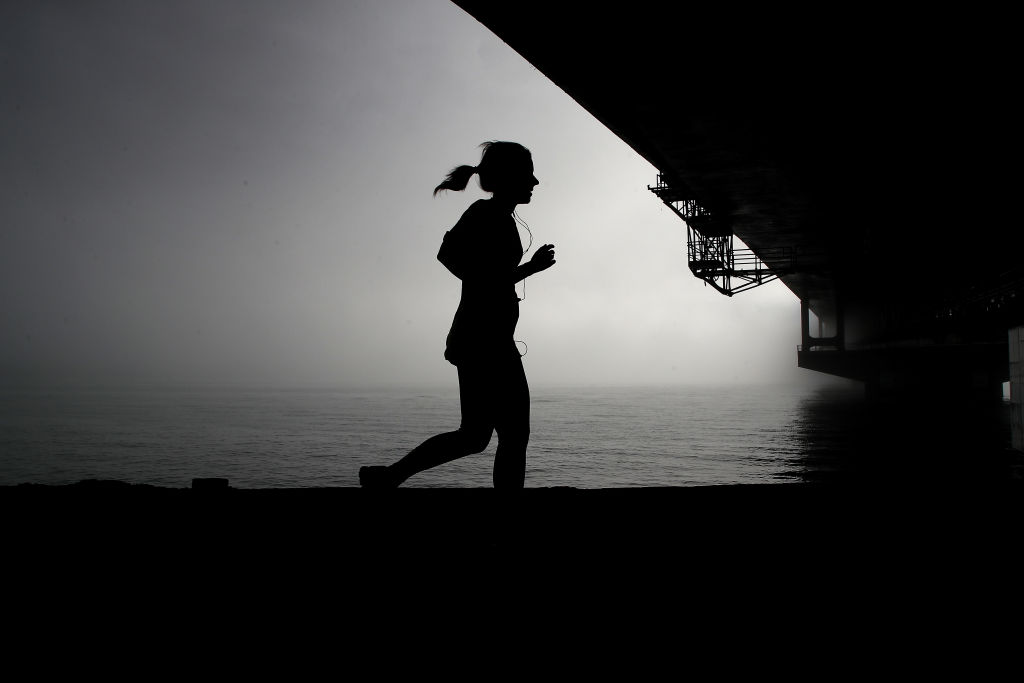 AUCKLAND, NEW ZEALAND - AUGUST 02: A morning jogger runs underneath Auckland Harbour Bridge as fog drifts over the harbour on August 2, 2018 in Auckland, New Zealand. Fog restrictions at Auckland Airport were lifted at 8:20am but not before the forced cancellation of 19 domestic flights. (Photo by Phil Walter/Getty Images)