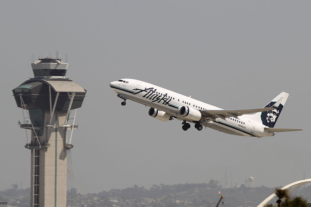 LOS ANGELES, CA - APRIL 22: An Alaska Airlines jet passes the air traffic control tower at Los Angles International Airport (LAX) during take-off on April 22, 2013 in Los Angeles, California. Delays have been reported throughout the nation because of the furloughing of air traffic controllers under sequestration. The average delay overnight in the Southern California Terminal Radius Approach Control (TRACON) was was three hours. (Photo by David McNew/Getty Images)