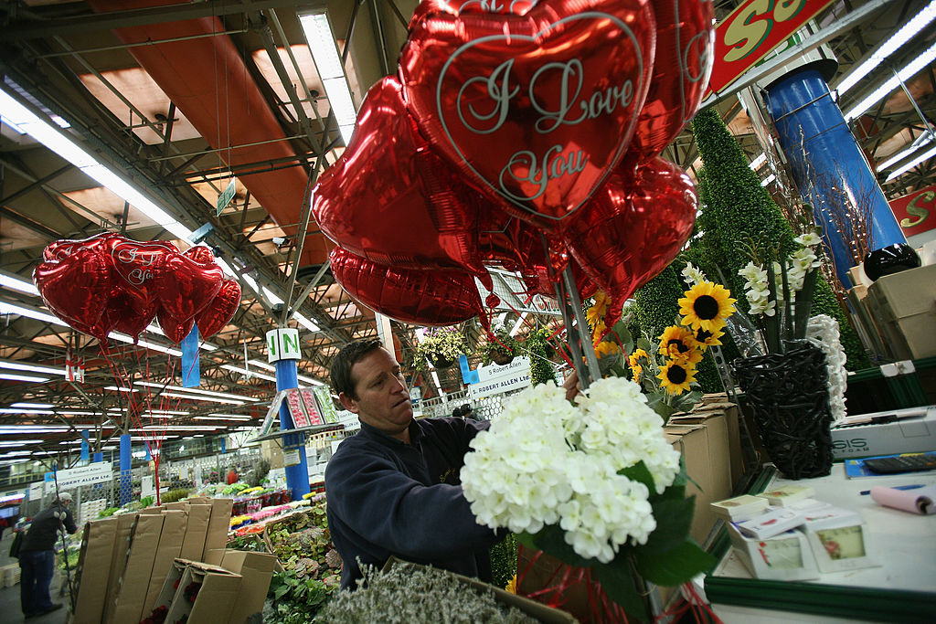 LONDON, ENGLAND - FEBRUARY 11: A market vendor attaches a bunch of Valentine balloons to his stall in New Covent Garden Flower Market on February 11, 2009 in London, England. New Covent Garden Flower Market is London's premier wholesale market, stocking the widest range of flowers, plants and foliage in the UK. British people spend around 50 million GBP on flowers and plants for Valentines, 99% of which is spent on flowers, with an estimated 9 million roses given. The week running up to St Valentines day is one of the busiest times of the year. (Photo by Dan Kitwood/Getty Images)