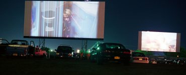 375759 09: "Me, Myself & Irene" and "Chicken Run" light up the screens at the Fiesta drive-in movie theater in Carlsbad, New Mexico, August 10, 2000. The death of the drive-in has been proclaimed far and wide. Back in the 1960s, more than 4,000 operated in the nation, according to the United Drive-In Theater Owners Association. Today there are around 500 throughout the nation. Drive-ins originally were built on the outskirts of town, where land was inexpensive. As cities grew so did property values, and many of the theaters were razed in favor of housing developments and malls. In the late ''70s and early ''80s, competition from indoor theater multiplexes and home videos helped reduce the number even further. But some of the surviving drive-ins are making a comeback such as the Fiesta drive-in that has been running for the last 10 years. (Photo by Joe Raedle/Newsmakers)